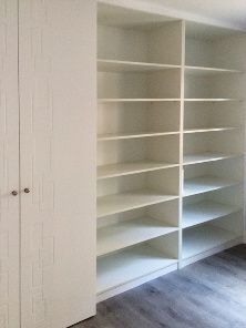 Un armario con muchos estantes y puertas en una habitación.