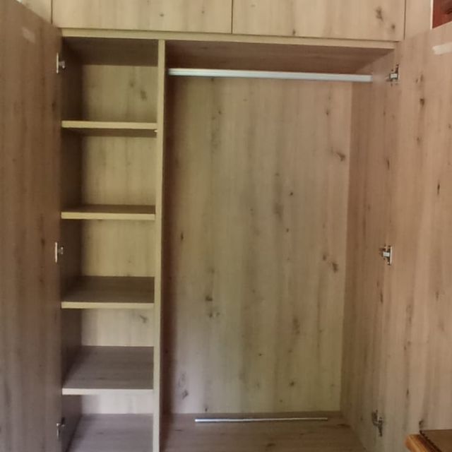 El interior de un armario de madera con la puerta abierta.