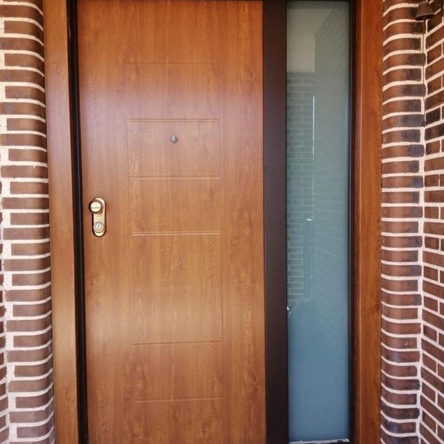 Una puerta de madera con una pared de ladrillos detrás