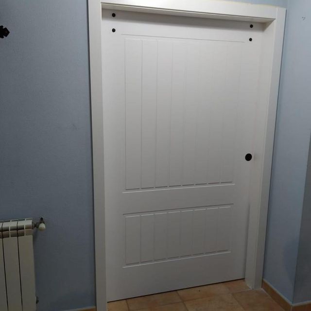 Una puerta blanca en un pasillo al lado de un radiador.