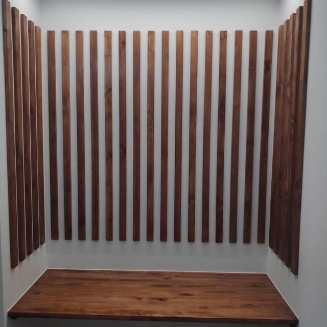 Una habitación con listones de madera en la pared y una mesa de madera.