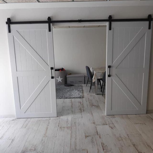 Una habitación con puertas corredizas de granero que conducen a un comedor.