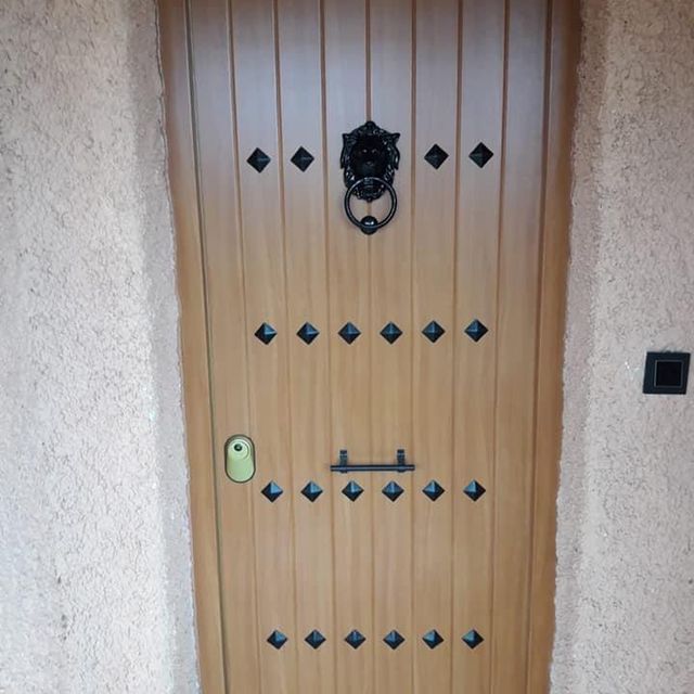 Una puerta de madera con un llamador negro en ella