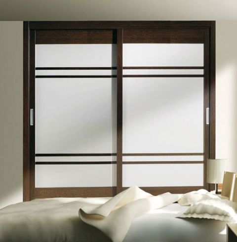 Un dormitorio con puertas corredizas de vidrio y una cama.