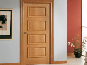 Una puerta de madera está en un pasillo al lado de un cuadro en la pared.