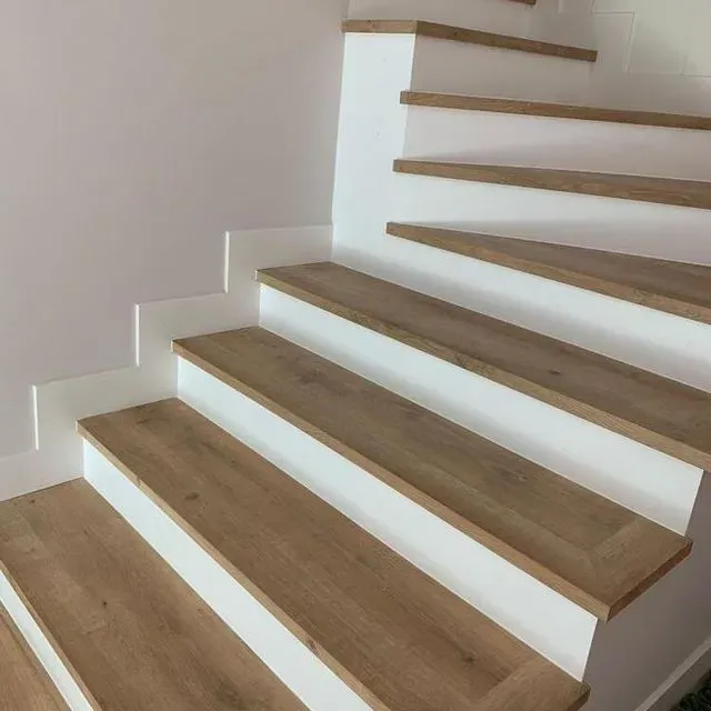 Un conjunto de escaleras con escalones de madera y paredes blancas.