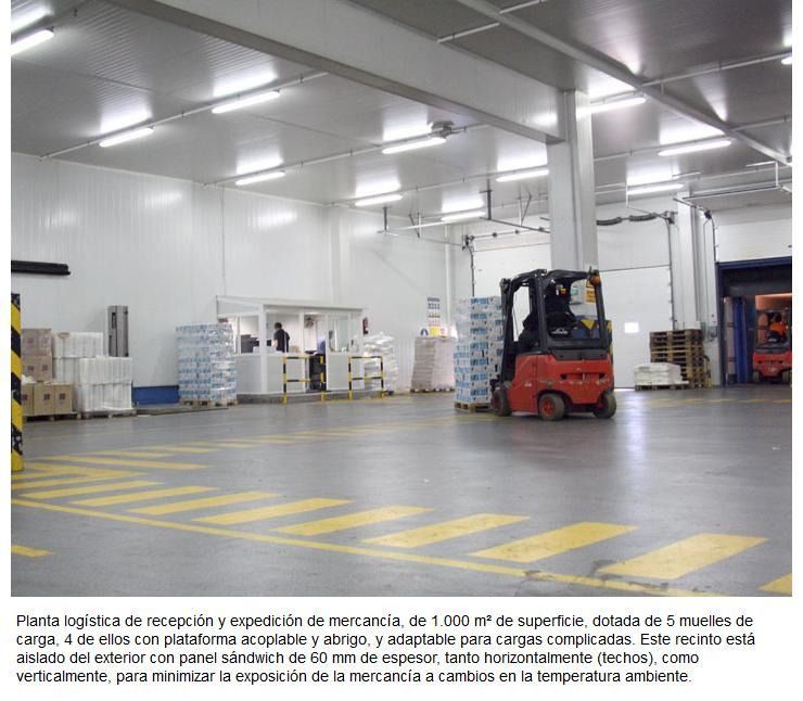 Una carretilla elevadora roja circula por un gran almacén.