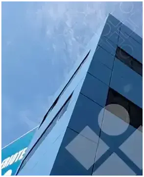 Mirando hacia arriba a un edificio alto con un cielo azul en el fondo.