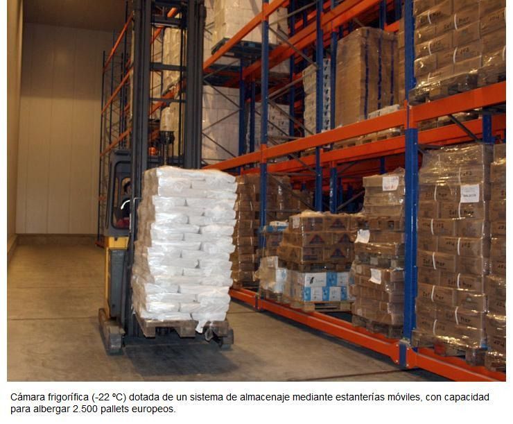 Una carretilla elevadora transporta una gran pila de bolsas en un almacén.