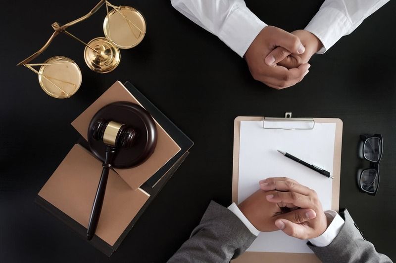 Dos hombres están sentados en una mesa firmando un documento.