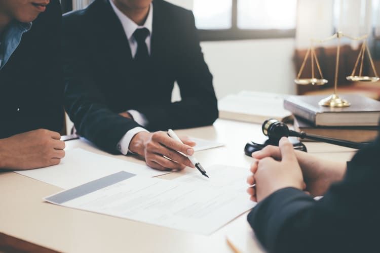 Un grupo de abogados está sentado en una mesa teniendo una reunión.