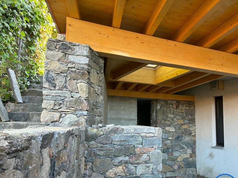 Esterno dell'edificio in pietra con travi in ​​legno e lucernario.