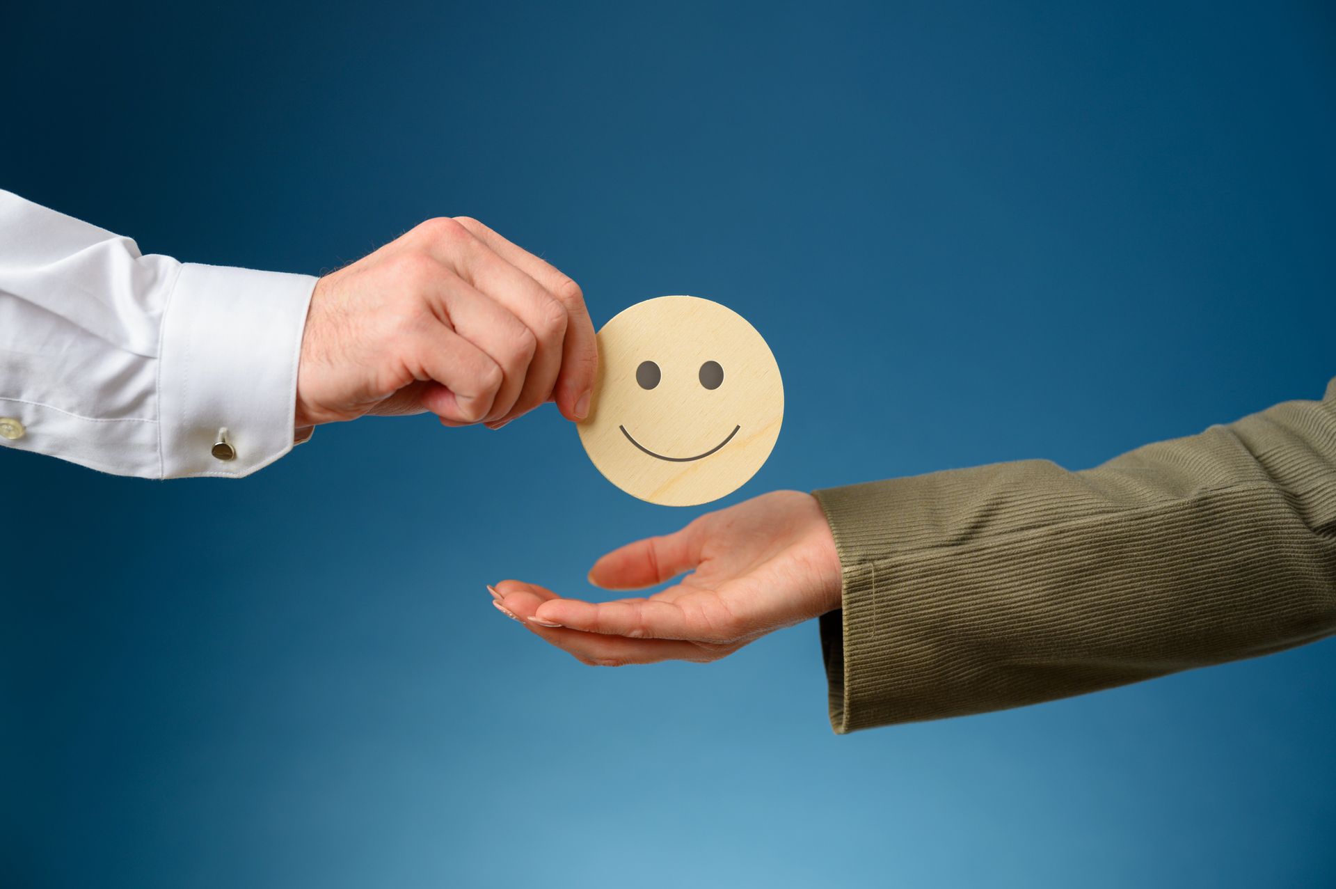 Une main qui tend un smiley à une autre main