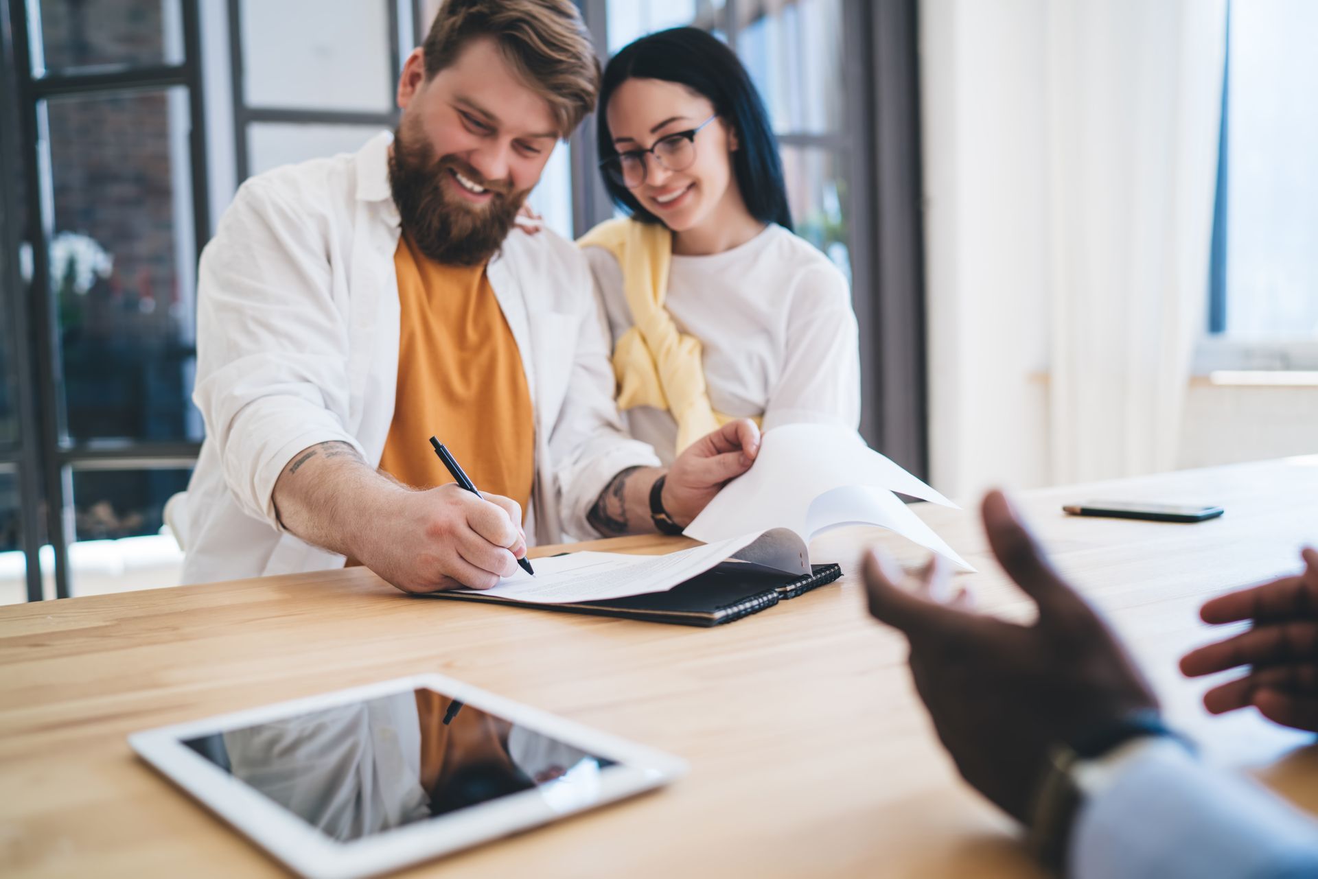 Un couple en train de signer un contrat
