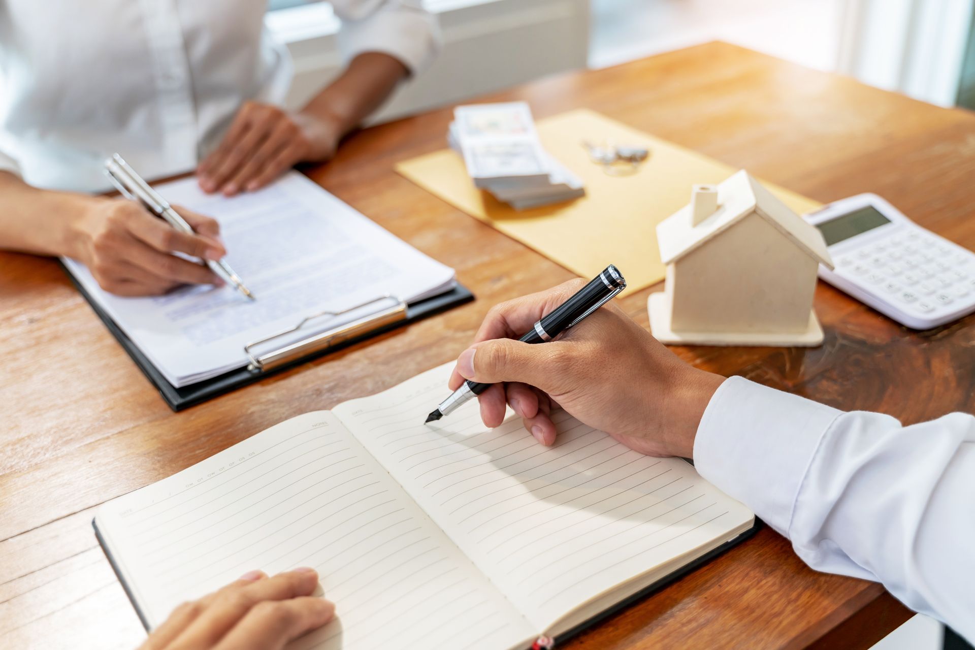 Deux personnes à un bureau en train de prendre des notes sur un contrat