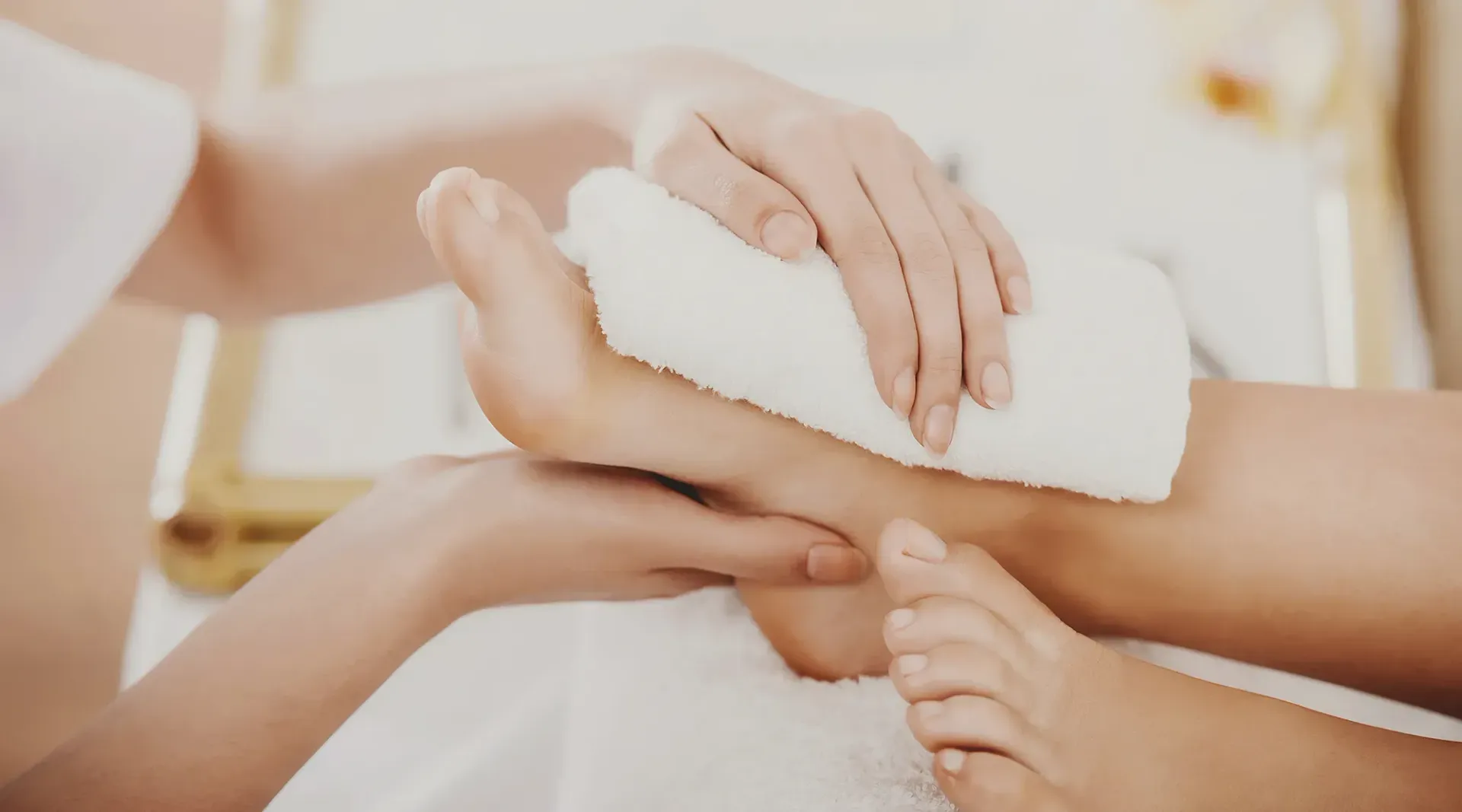 Eine Frau bekommt eine Fußmassage mit einem Handtuch.