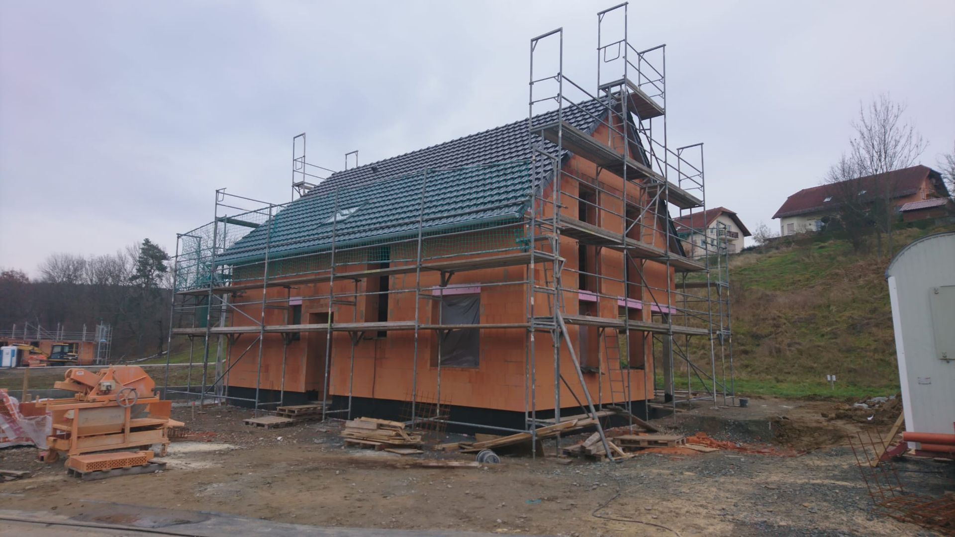 Ein Gebäude im Rohbau mit eingerüstetem Dach während einer Dachsanierung.