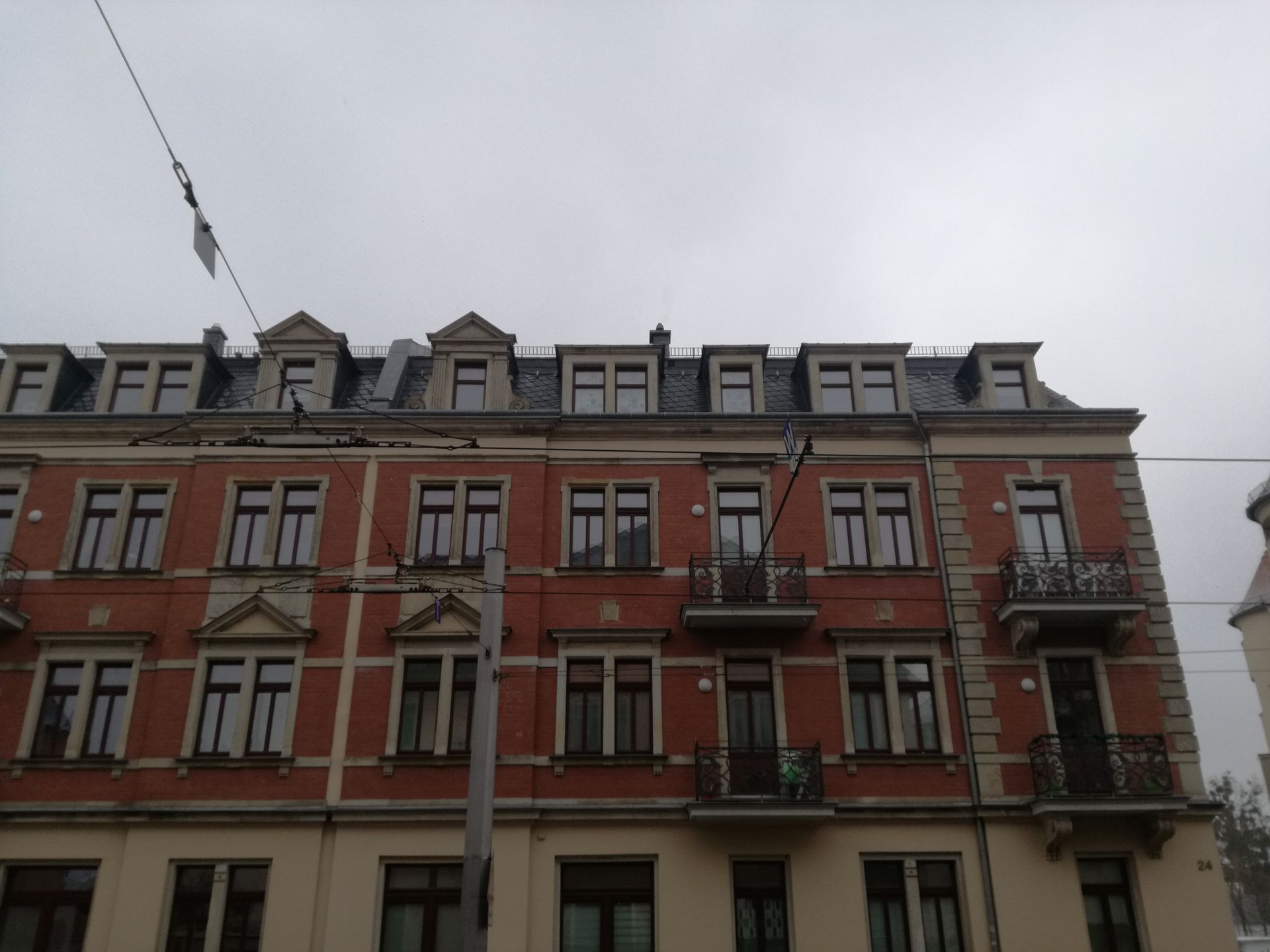 Mehrstöckiges Wohngebäude mit frisch saniertem Dach und Baukran.