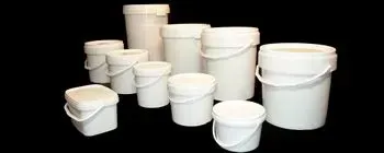 Un grupo de cubos de plástico blanco con asas sobre un fondo negro.