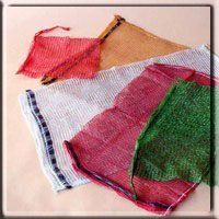 Un grupo de bolsas de malla de colores están colocadas una encima de otra sobre una mesa.