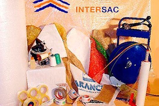 Un montón de suministros de embalaje están sobre una mesa con un cartel que dice intersac