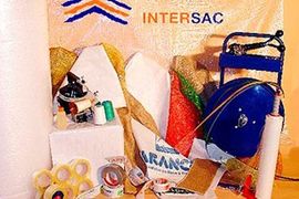 Un montón de suministros de embalaje están sobre una mesa con un cartel que dice intersac