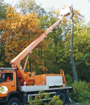 Ein orangefarbener LKW mit einem Kran darauf