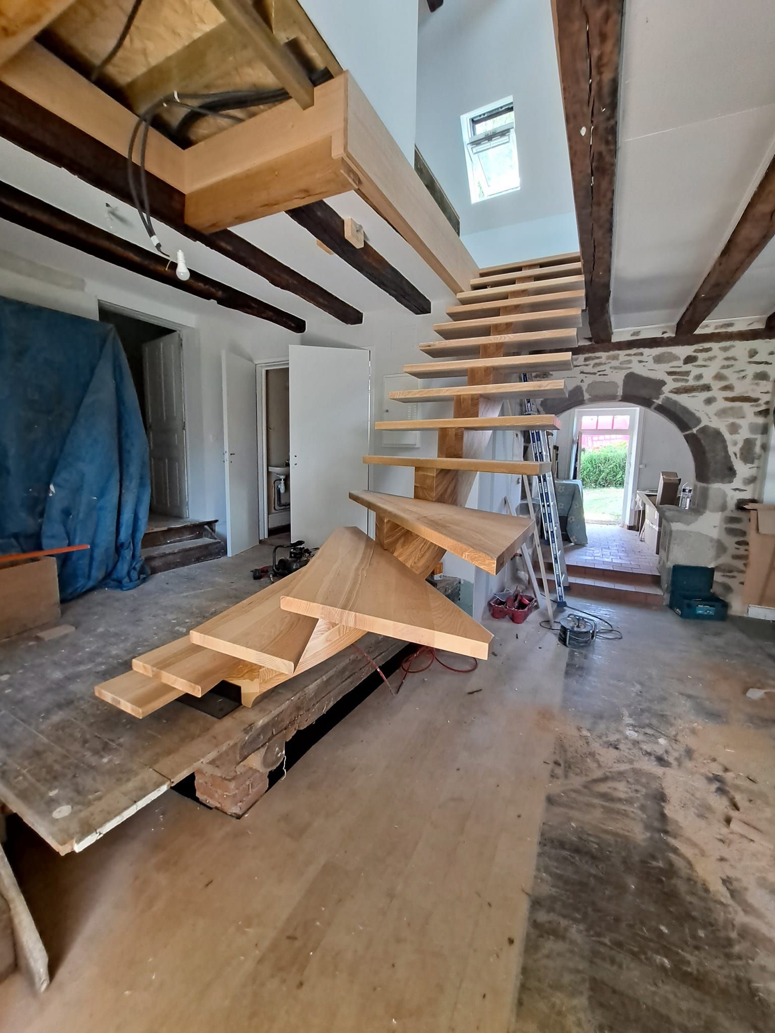 Maison avec une charpente et un escalier de bois