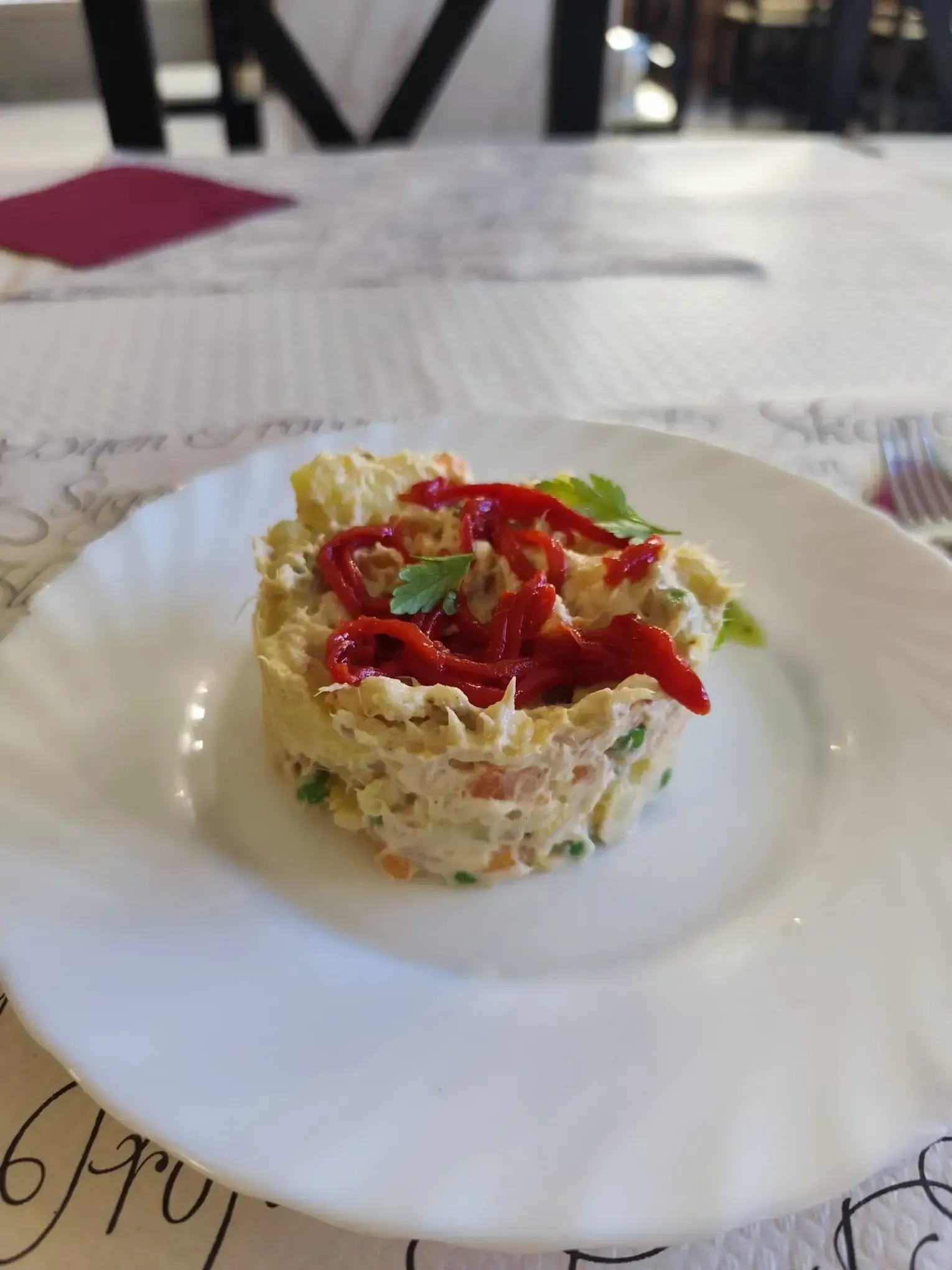 Ensalada de patatas con pimientos rojos en un plato blanco.