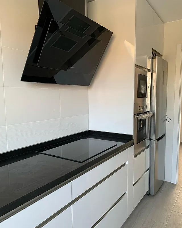 Una cocina con estufa, horno y refrigerador.