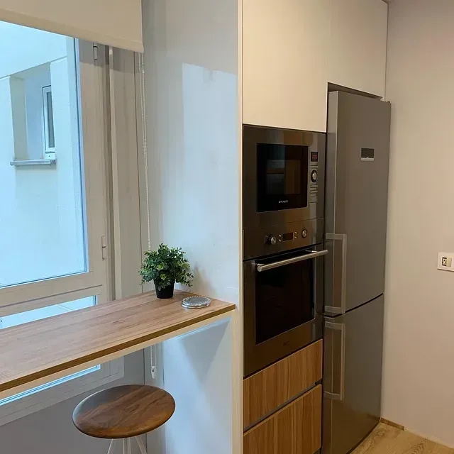 Una cocina con refrigerador de acero inoxidable, horno y microondas.