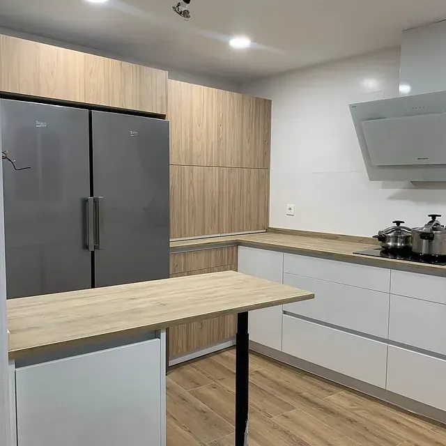 Una cocina con electrodomésticos de acero inoxidable y gabinetes de madera.