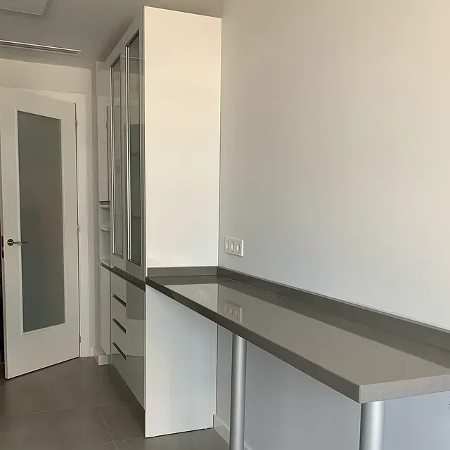 Una habitación con un escritorio y armarios y una puerta.