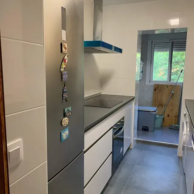 Una cocina con un refrigerador que tiene muchos imanes.