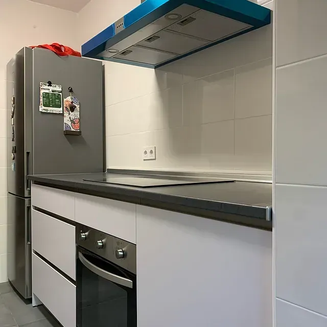 Una cocina con estufa, horno y refrigerador.