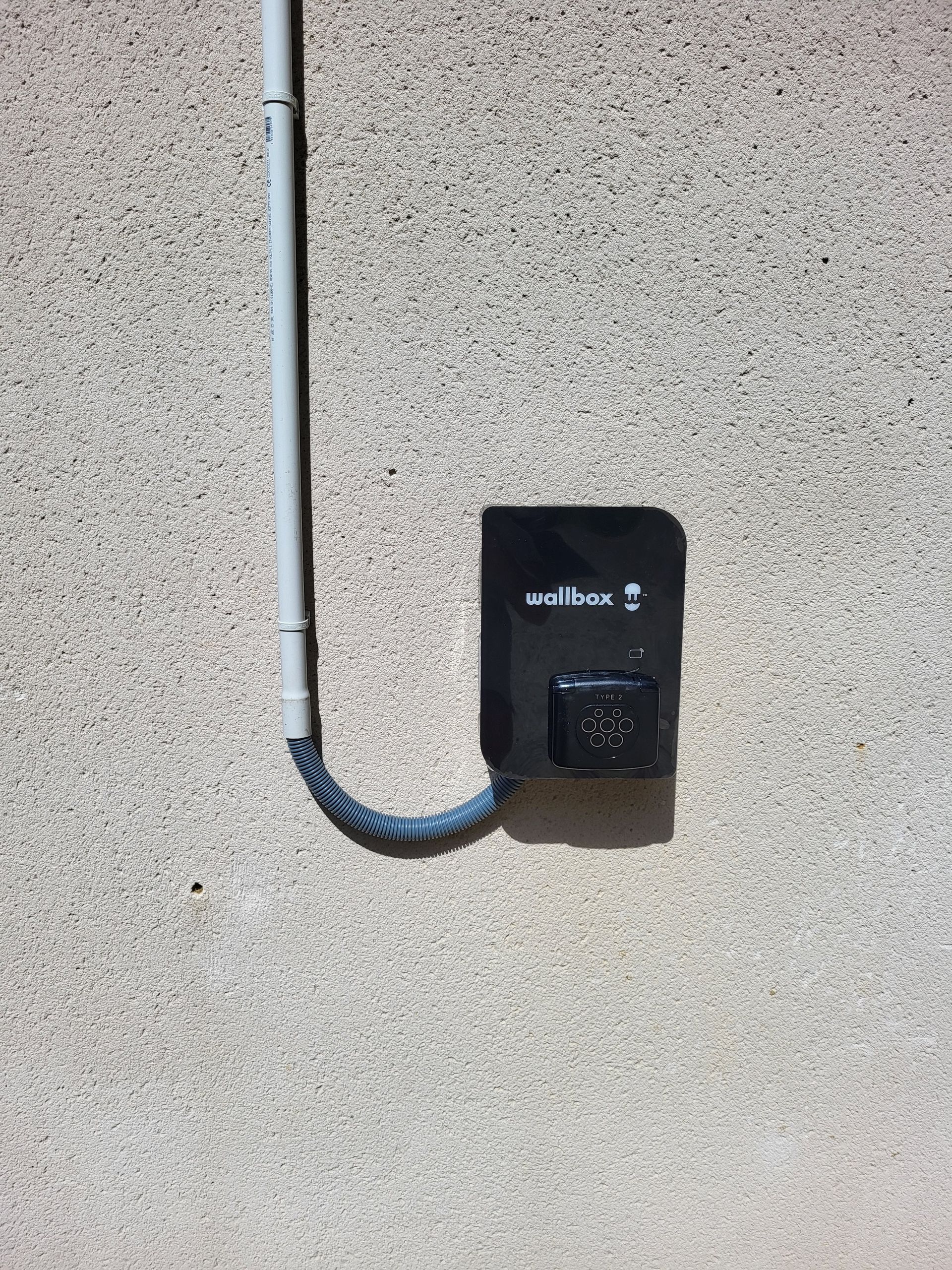 Une borne noire avec un câble gris