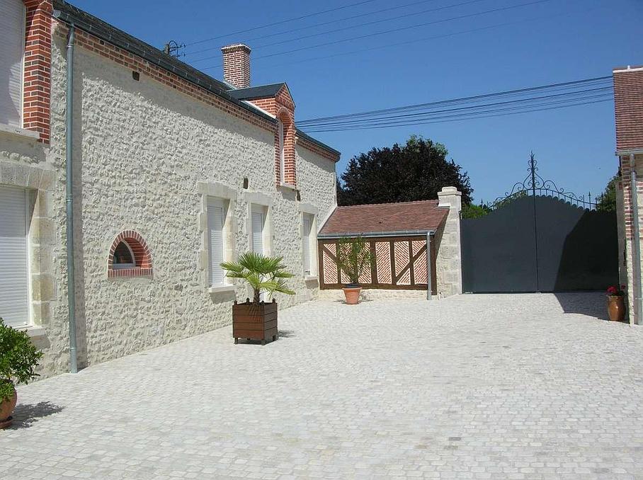 Maison en pierre blanche et cour extérieure