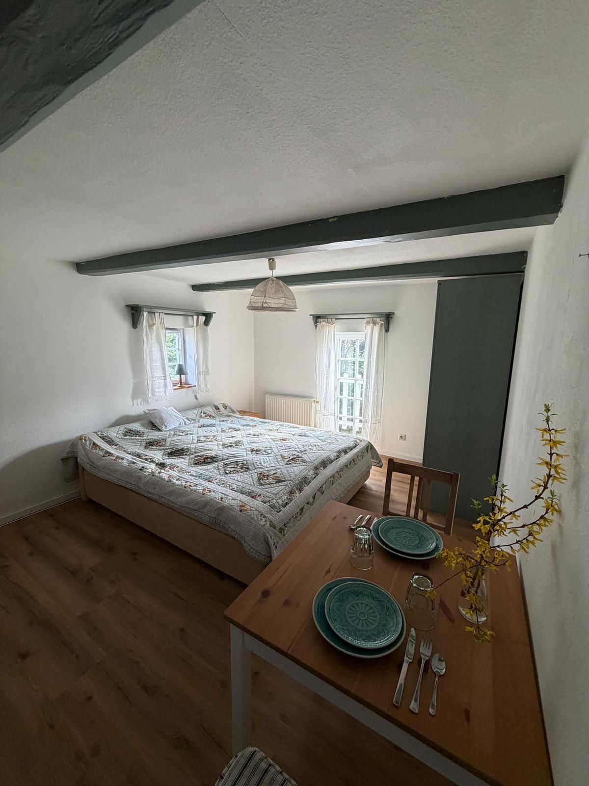 Helles Gästezimmer im Auengut mit Boxspringbett, moderner Einrichtung und Blick ins Grüne der Oberlausitz.
