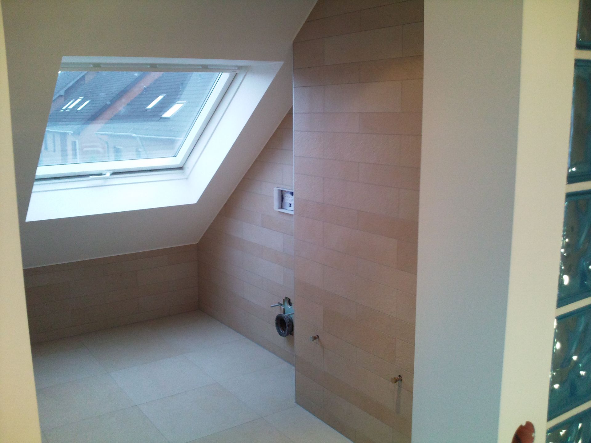 Badezimmer mit Dachschräge und Oberlicht. Beige Wände und Boden, weiße Zierleisten.