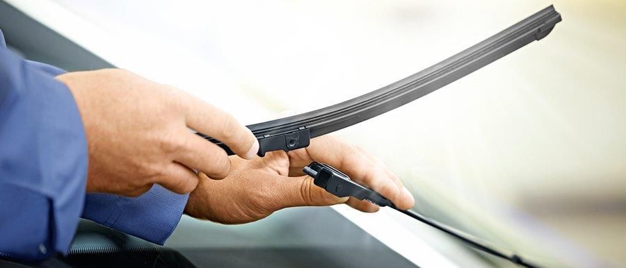 Eine Person hält einen Scheibenwischer in den Händen.