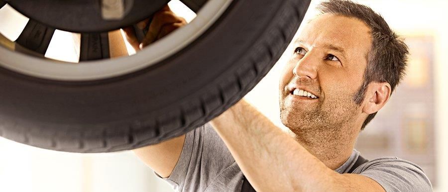 Ein Mann arbeitet in einer Garage an einem Reifen.