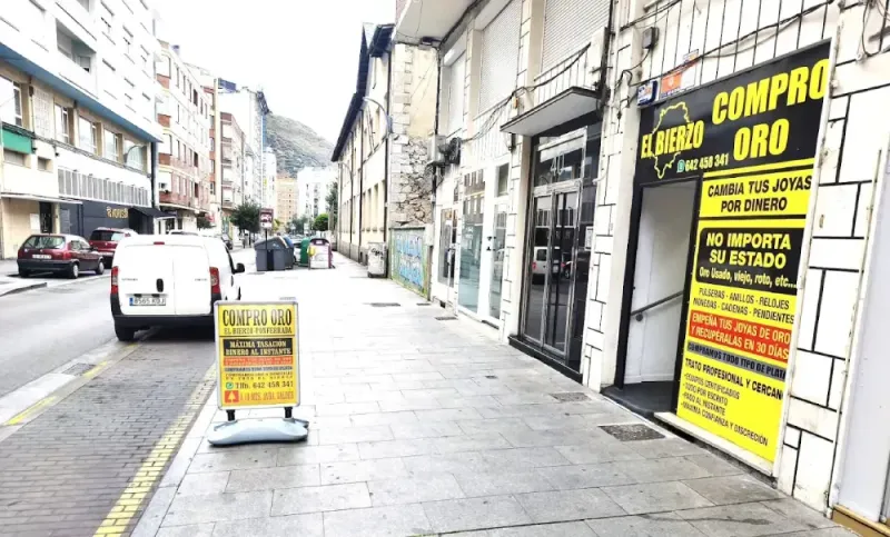 Acera con tiendas; letrero de 