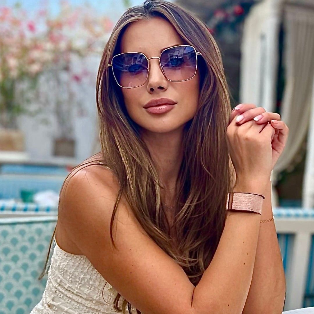 Une femme qui pose avec des lunettes de soleil