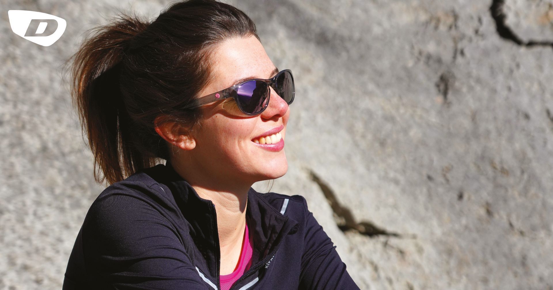 Une femme avec des lunettes de soleil qui sourit