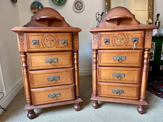 Dos mesitas de noche de madera con cajones y elementos decorativos, situadas en el interior.