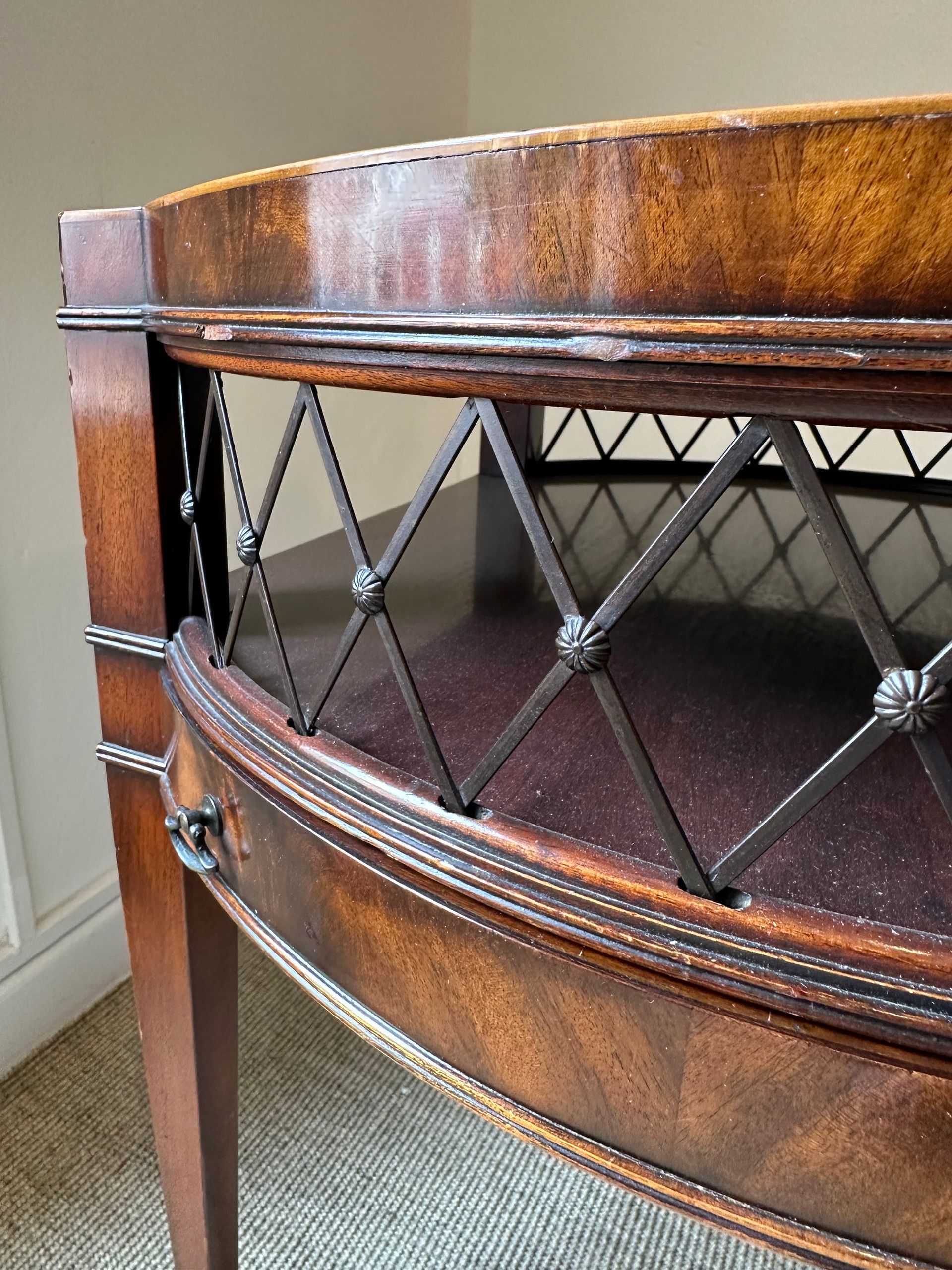 Mesa auxiliar de madera con rejilla metálica en forma de rombo, color marrón oscuro con vetas de madera clara.