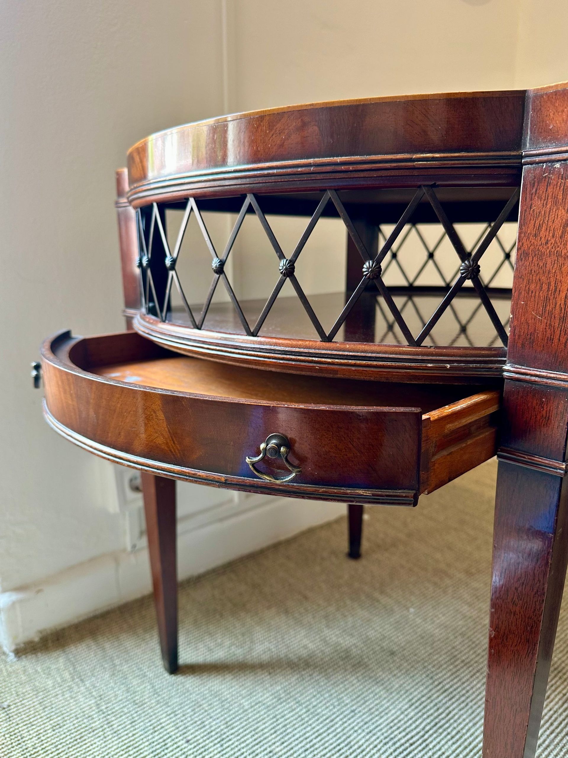 Elegante mesa auxiliar de caoba con cajón, celosía y patas torneadas.