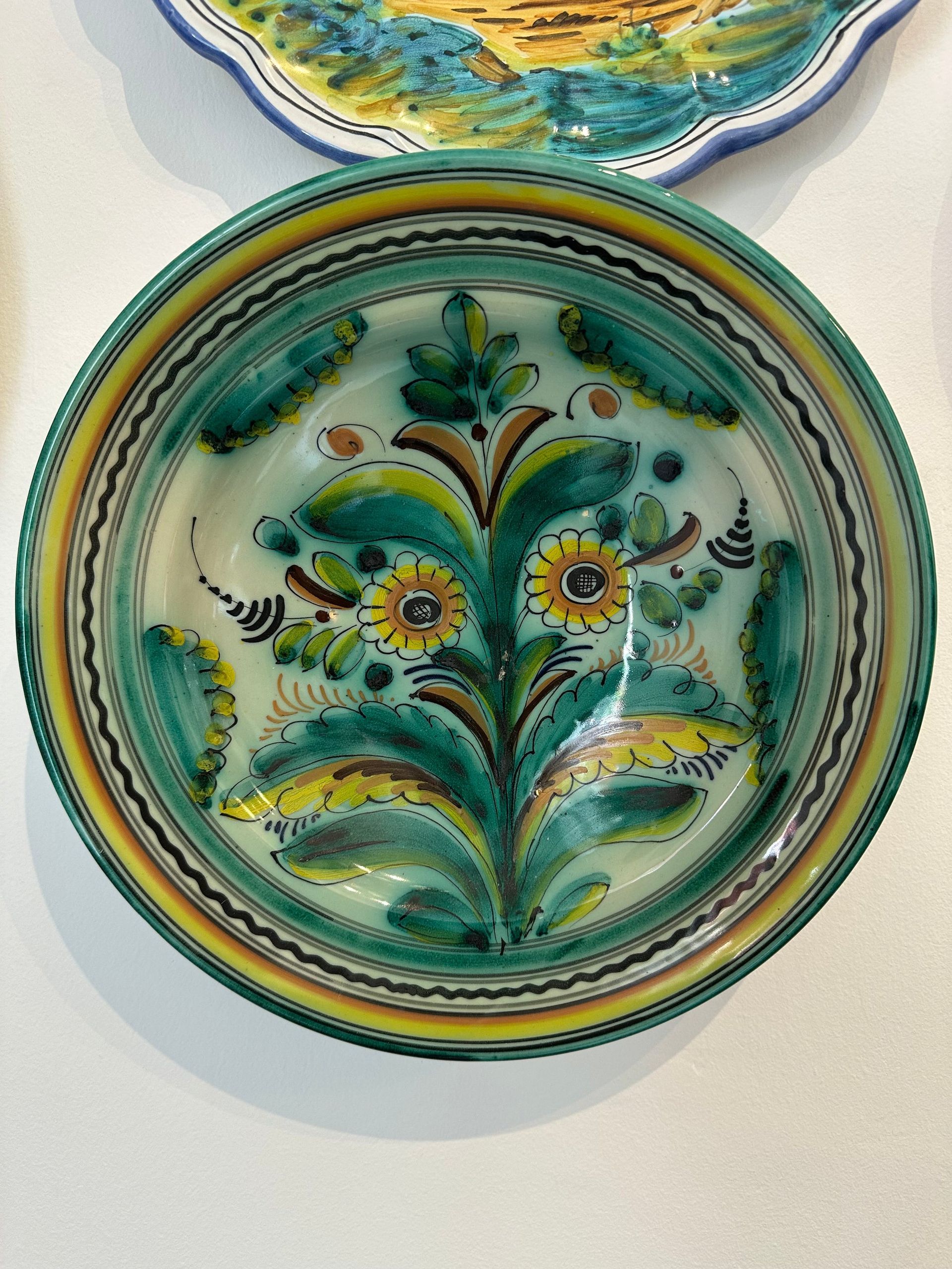 Cuenco de cerámica con diseño floral en tonos verdes, amarillos y marrones.