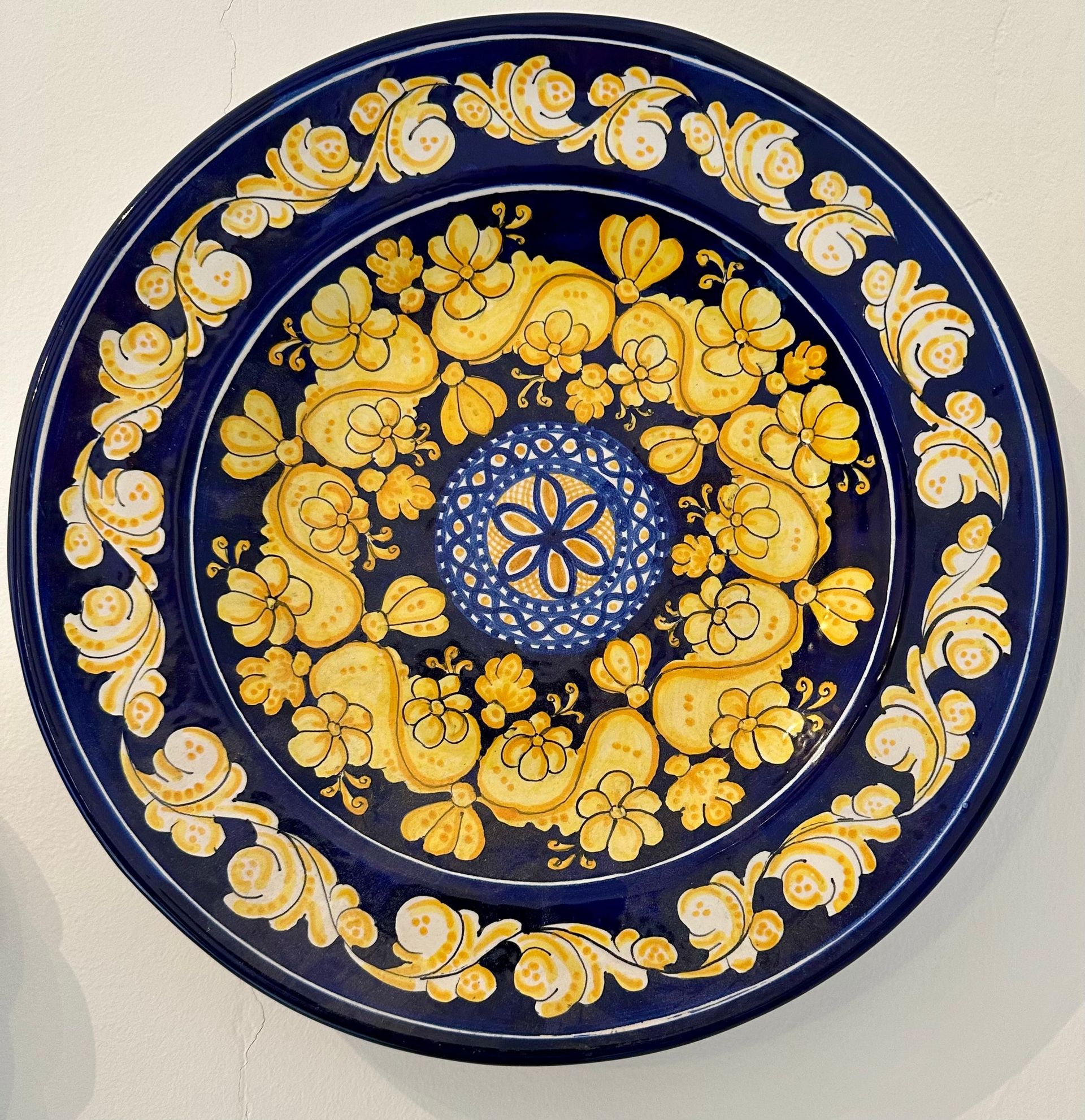 Plato de cerámica azul con diseño floral amarillo.