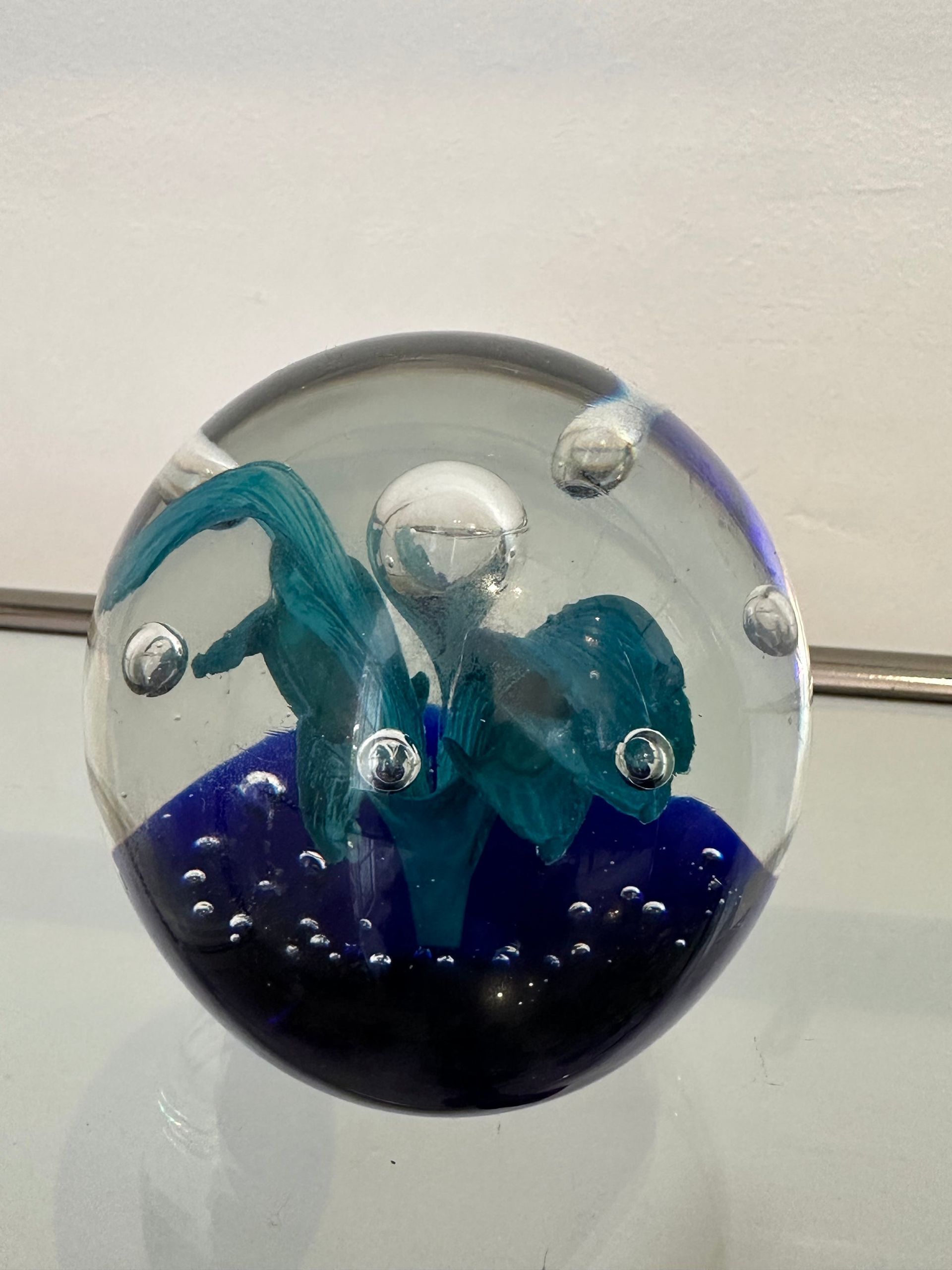 Pisapapeles de cristal con remolinos y burbujas de color azul y verde azulado.